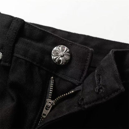 Jean noir à motif cœurs chromés, blanc et jaune, avec écusson en croix.