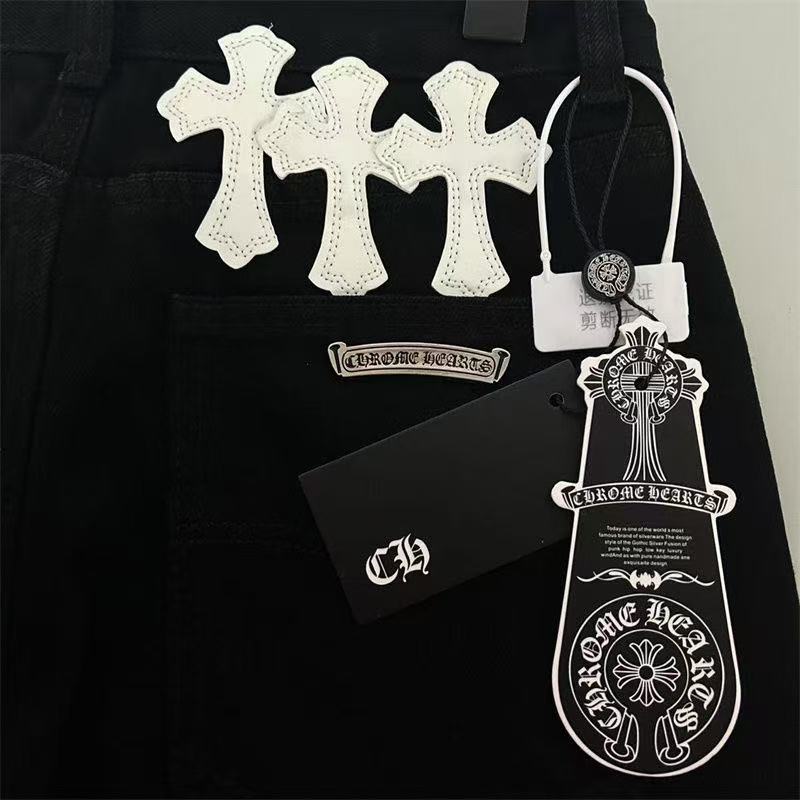 Jean noir à motif cœurs chromés, blanc et jaune, avec écusson en croix.