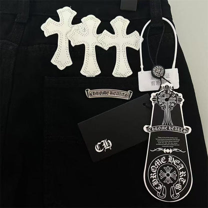 Jean noir à motif cœurs chromés, blanc et jaune, avec écusson en croix.