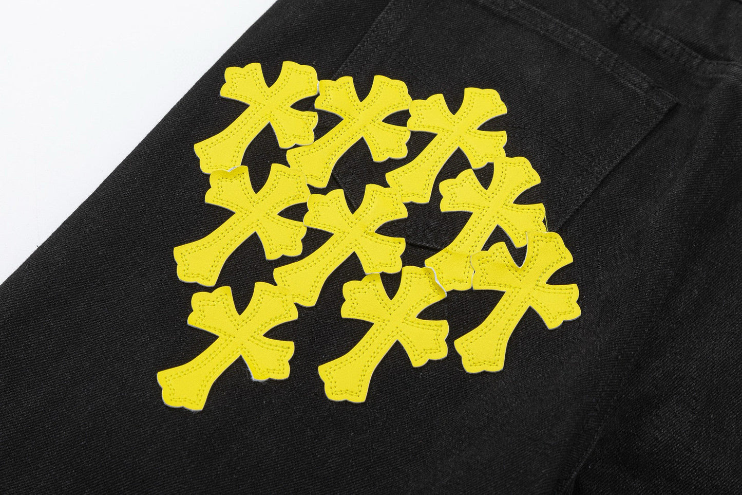 Jean noir à motif cœurs chromés et croix jaune