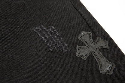 Jean noir à motif cœurs chromés et croix.