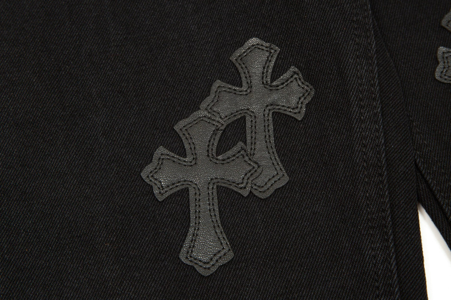 Jean noir à motif cœurs chromés et croix.